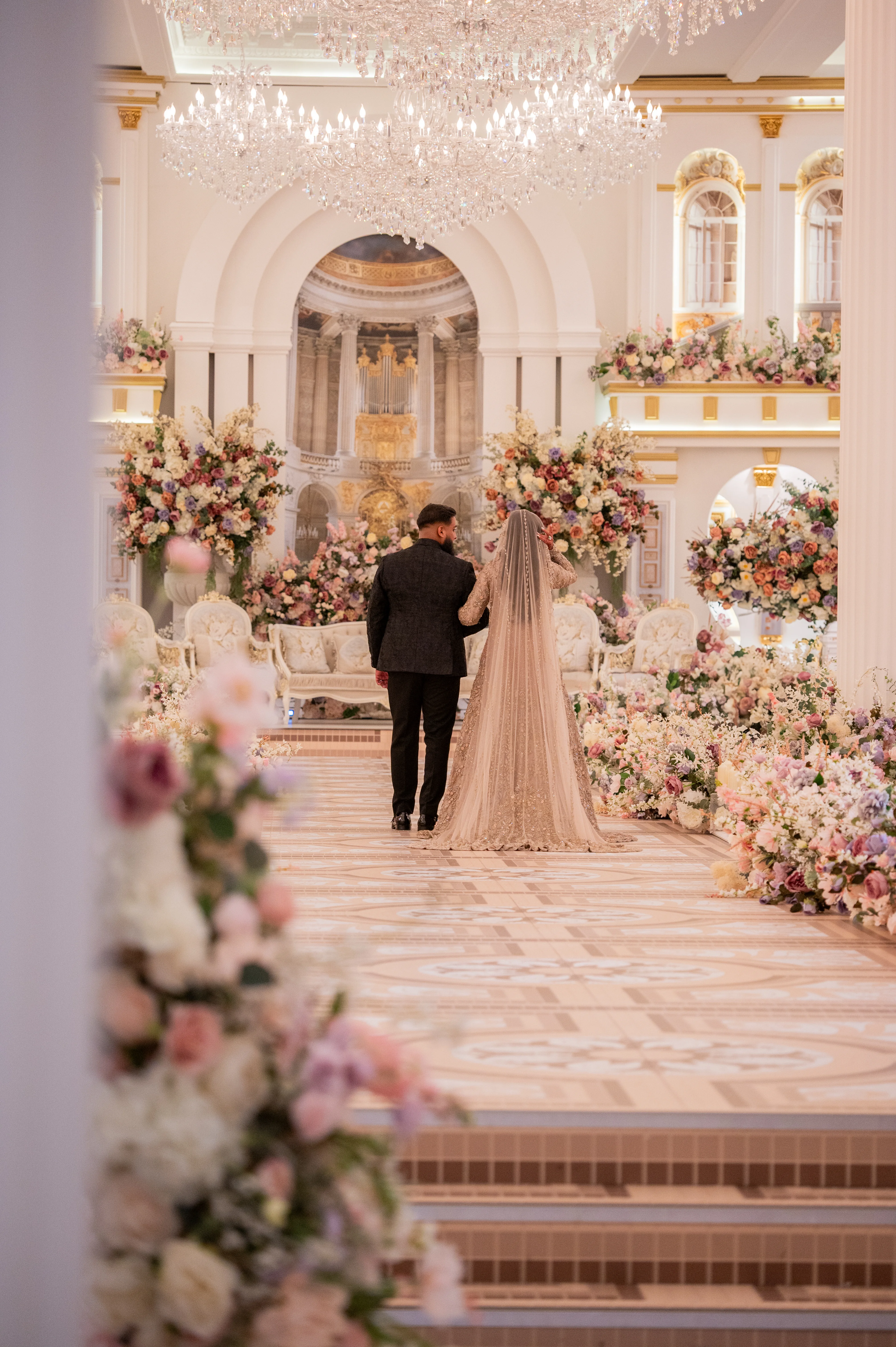 Couple walking down the aisle at a grand floral Walima reception, photographed by Eyecon Moments
